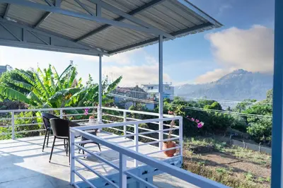 a balcony with chairs and a view of the mountains at The Jade Highlands Mountain View Container Studio Room in Kodaikānāl