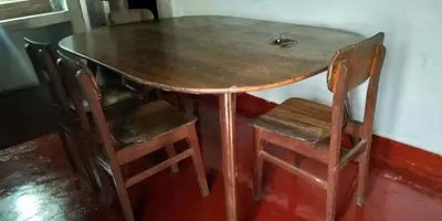 a wooden table and chairs with a engagement ring on it at Sundara vana estate stay madikeri in Madikeri