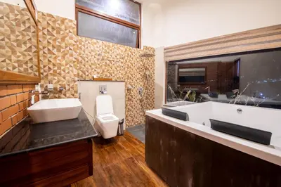 a bathroom with a sink and a toilet and a tub at Asta in Ooty