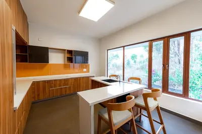 a kitchen with a table and chairs and a large window at Asta in Ooty