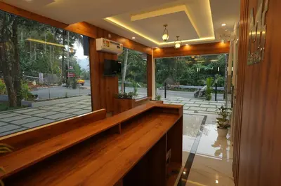 a lobby with a wooden bench and a large window at M!steria Inn in Wayanad