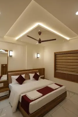a bedroom with a large bed with a ceiling fan at M!steria Inn in Wayanad