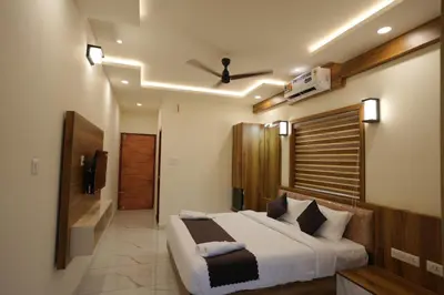 a bedroom with a large bed and a bathroom at M!steria Inn in Wayanad