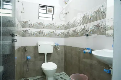 a bathroom with a toilet and a sink at Adam homes in Alwaye