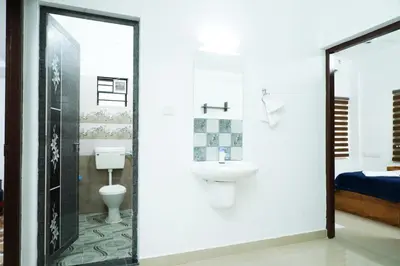 a bathroom with a toilet and a sink at Adam homes in Alwaye