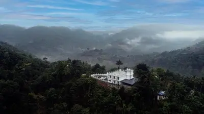 a house on a hill in the middle of a forest at Karickanattu Nature Resort in Idukki