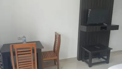 a room with a table and a television and a chair at Karickanattu Nature Resort in Idukki