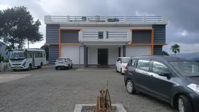 a parking lot with cars parked in front of a building at Karickanattu Nature Resort in Idukki