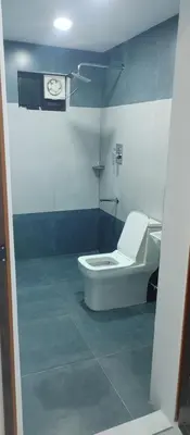 a bathroom with a toilet and a clock on the wall at Kashmir Valley in Kanthalloor