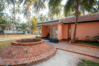 a house with a brick patio in front of it at Baywatch by Grha - A Picturesque Beachfront Villa in Kozhikode