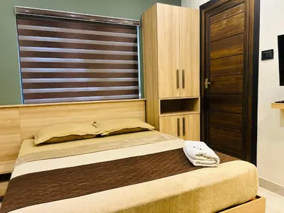 a bed in a room with a large window at NIDRA INN in Kozhikode