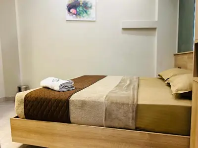a bed with a wooden frame with a towel on it at NIDRA INN in Kozhikode