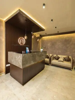 a lobby with a reception desk and a couch at NIDRA INN in Kozhikode