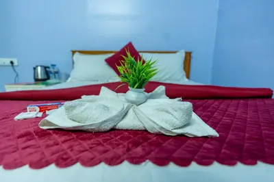 a bed with a flower arrangement in a vase on it at Aryas Residency- Near Isha Foundation Coimbatore & Adiyogi statue in Alāndurai