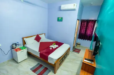 a bedroom with a bed and a blue wall at Aryas Residency- Near Isha Foundation Coimbatore & Adiyogi statue in Alāndurai