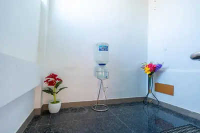 a room with two flowers and a water bottle on a wall at Aryas Residency- Near Isha Foundation Coimbatore & Adiyogi statue in Alāndurai