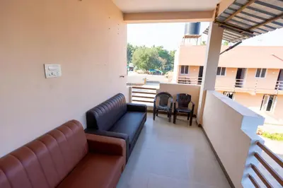 a balcony with couches and chairs on a building at Aryas Residency- Near Isha Foundation Coimbatore & Adiyogi statue in Alāndurai