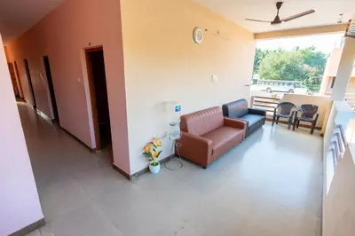 a living room with a couch and a table at Aryas Residency- Near Isha Foundation Coimbatore & Adiyogi statue in Alāndurai