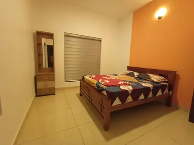 a bedroom with a bed in a room with a window at Eden Homestays in Wayanad