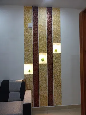 a room with a wall with three lights and a couch at Eden Homestays in Wayanad