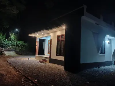 a small house at night with the lights on at Eden Homestays in Wayanad