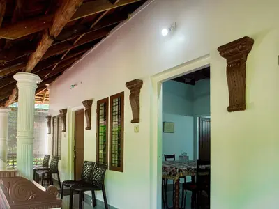 a dining room with a table and chairs and a ceiling at Sanctuary View Homestay Thattekad in Ernakulam