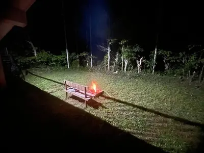 a bench with a fire in a field at night at Senthamarai villa in Sultan Bathery