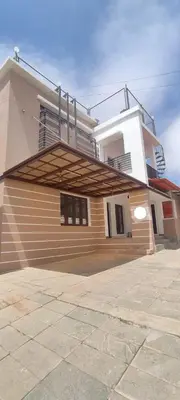 a house with a staircase in front of it at OOTY LIMRA HOLIDAY INN cottage in Ooty