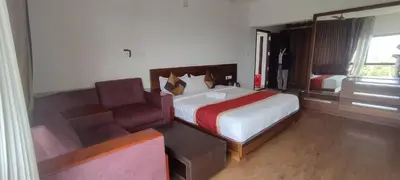 a hotel room with a bed and a couch at OOTY LIMRA HOLIDAY INN cottage in Ooty