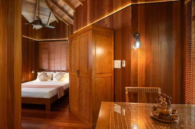 a bedroom with a bed and a table in a room at Villa Woods & Palms in Pollāchi