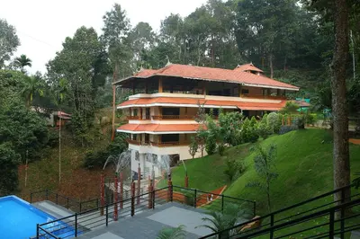 a large house on top of a hill at Peter's Coffee Creek Wayanad Pool Resort in Wayanad