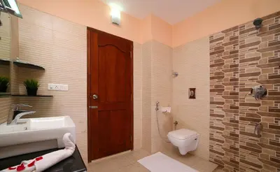 a bathroom with a toilet and a sink at Peter's Coffee Creek Wayanad Pool Resort in Wayanad