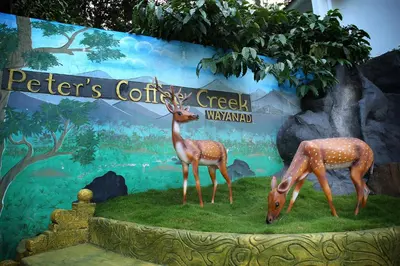 a display of two deer in front of a sign at Peter's Coffee Creek Wayanad Pool Resort in Wayanad