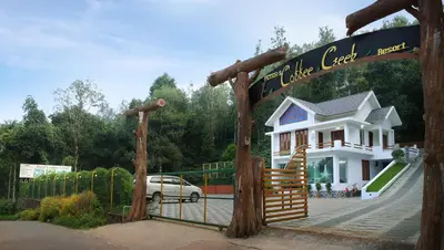 a house with a gate in front of it at Peter's Coffee Creek Wayanad Pool Resort in Wayanad