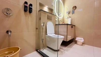 a bathroom with a toilet and a glass shower at Aranyasun in Masinagudi