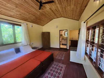 a bedroom with a large bed with a wooden ceiling at Aranyasun in Masinagudi
