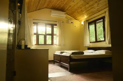 a small bedroom with a bed and a window at Aranyasun in Masinagudi