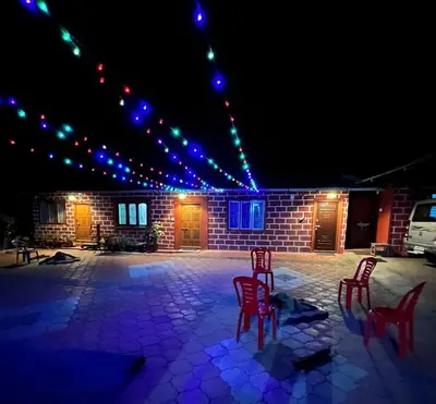 a group of red chairs sitting in a patio at night at cocostay coorg in Madikeri