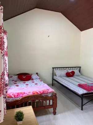 two beds in a room with red pillows on them at cocostay coorg in Madikeri