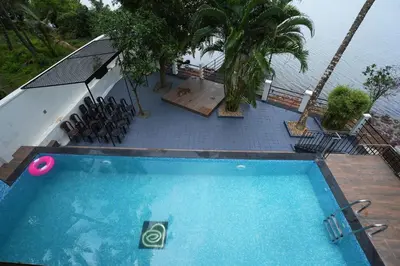 an overhead view of a swimming pool with chairs and the water at Bellevue Homestay and Wellness Centre in Kozhikode