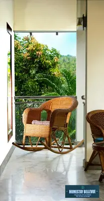 a wicker chair sitting on a porch with a window at Bellevue Homestay and Wellness Centre in Kozhikode