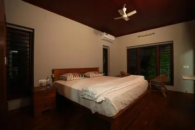 a bedroom with a bed and a ceiling fan at Bellevue Homestay and Wellness Centre in Kozhikode