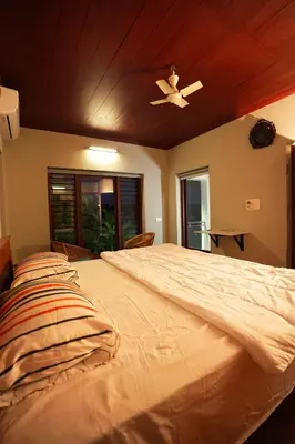 a bedroom with a large bed with a ceiling at Bellevue Homestay and Wellness Centre in Kozhikode