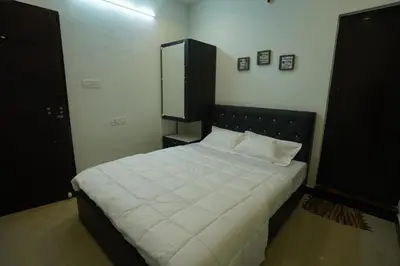 a bedroom with a large white bed with a black headboard at Casa de Selas in Coonoor