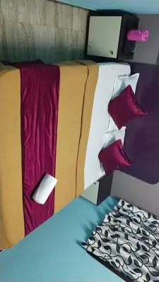 a close up of a bed with red pillows at Misty Stay by Le Apex in Ooty