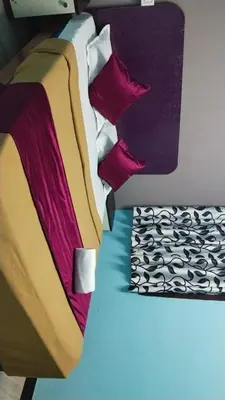 a bed with colorful blankets and pillows on it at Misty Stay by Le Apex in Ooty