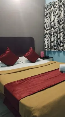 a bedroom with two beds with red pillows at Misty Stay by Le Apex in Ooty