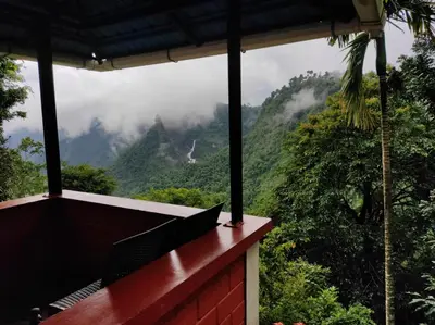 a balcony of a house with a view of the mountains at Valley View Avenue in Meppādi