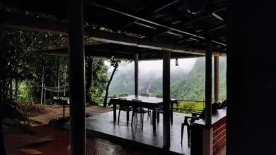 a table and chairs on a porch with a view of a mountain at Valley View Avenue in Meppādi