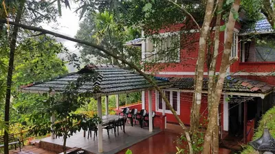 a patio with a table and chairs in front of a house at Valley View Avenue in Meppādi